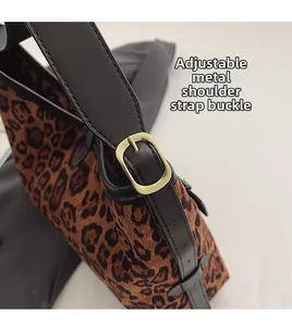 Détail du cabas léopard avec bandoulière réglable en cuir noir et boucle dorée en métal