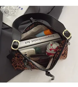 Gros plan de l'intérieur du sac léopard montrant la grande capacité et la poche zippée