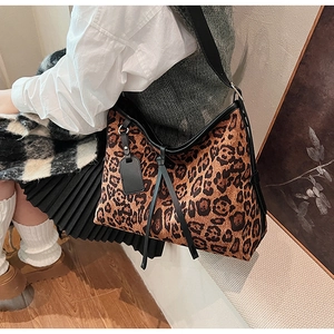 Gros plan du sac cabas à imprimé léopard avec bordure noire et étiquette cuir
