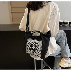 Modische schwarze Tragetasche mit Paisley-Muster aus der Rückansicht am Model gezeigt