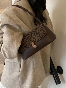 Vintage leopard print shoulder bag in dark brown with retro metal buckle on a model