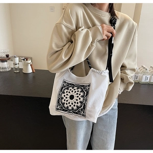 Detailansicht einer weißen Canvas-Tragetasche mit schwarzem Mandala-Muster und Tragegurt