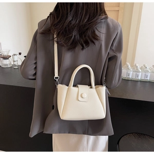 Vue arrière d'un mannequin portant un sac seau en cuir grainé blanc crème en bandoulière