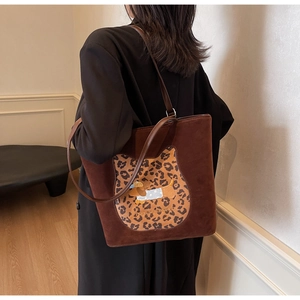 Detail of a brown suede tote bag with leopard print cat patch and dachshund embroidery