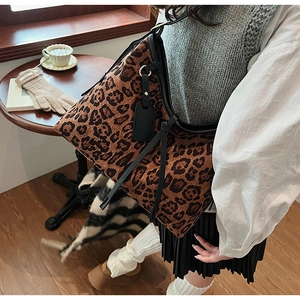 Détail du sac cabas imprimé léopard avec bordure en cuir noir et bandoulière longue