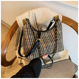 Detail of retro plaid shoulder bag with gold chain strap and textured fabric surface