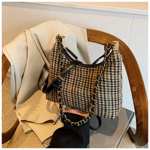 Detail shot of vintage houndstooth texture bag with gold chain strap for stylish women