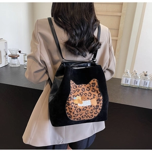 Rear view of a model wearing the black tote backpack with leopard cat ears and puppy embroidery
