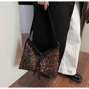 Détail du sac cabas à imprimé léopard avec lanières en cuir noir et texture en toile