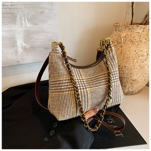 Detail of vintage plaid hobo bag with thick gold chain and brown leather strap