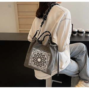 Detail der grauen Paisley-Canvas-Tasche mit Kordelzugverschluss und Seilgriffen