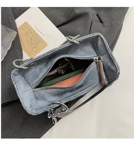 Interior view of denim tote bag showing space for phone, wallet and silver zipper