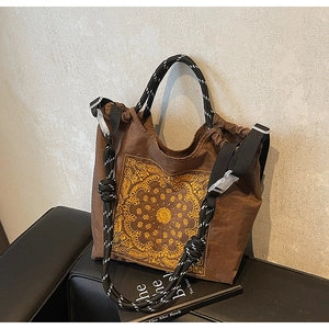 Detail der braunen Vintage-Einkaufstasche mit gelbem Mandala-Druck und Seilgriffen