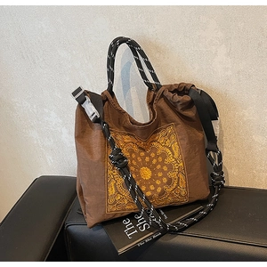 Detailansicht der braunen Paisley-Tasche mit geflochtenen Seilgriffen und Kordelzug