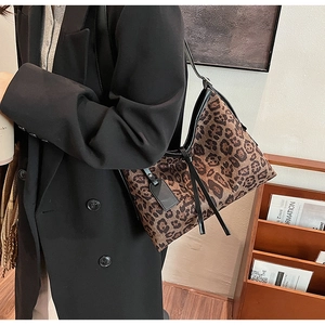 Détail du sac à bandoulière léopard avec des étiquettes en cuir noir et fermeture