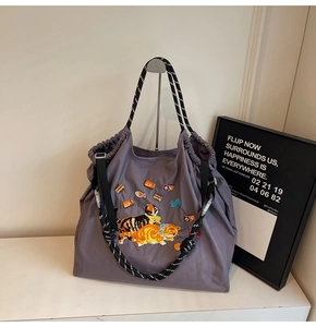 Detail der süßen Katzenstickerei auf einem grauen Shopper mit gepunkteten Griffen