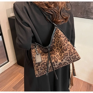 Détail du sac cabas léopard avec bordure noire et pendentif décoratif élégant