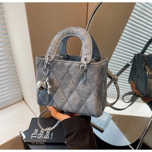 Detail of grey quilted handbag with silver charms and adjustable shoulder strap