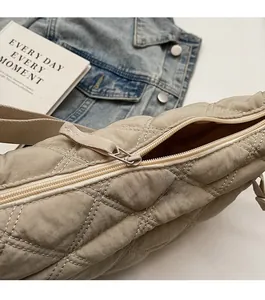 Detailed close-up of smooth metal zipper and quilted fabric on the khaki hobo bag