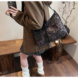Détail du sac cabas vintage imprimé léopard avec bretelles en cuir noir à l'épaule