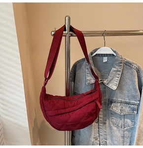 Detail of burgundy quilted nylon crescent bag with adjustable wide shoulder strap