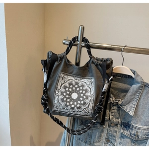 Detail der Vintage-Canvas-Tasche mit Paisley-Muster und geflochtenen Seilgriffen