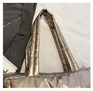 Détail des poignées matelassées d'un sac cabas métallisé pour un transport confortable