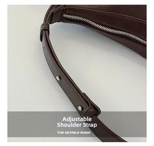 Detailed view of dark brown leather shoulder bag with adjustable strap and silver metal studs