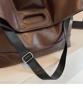 Detail of adjustable nylon strap and dark brown soft PU leather on large tote bag