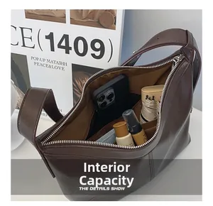 Detail view of large internal capacity for brown leather shoulder bag with zipper closure
