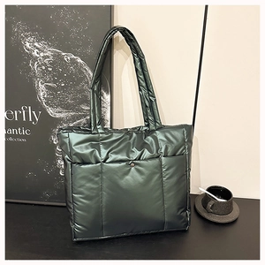 Gros plan sur le sac fourre-tout matelassé vert foncé métallisé avec poche à bouton-pression