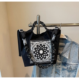 Nahaufnahme der schwarzen Canvas-Tasche mit Bandana-Print und gewebten Seilgriffen