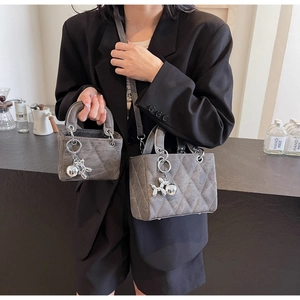 Detail showing two sizes of gray quilted bags with matte finish and silver dog charms