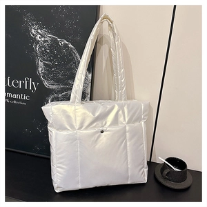Détail d'un sac cabas matelassé blanc en nylon brillant avec petite poche avant