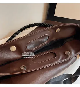 Detail of large tote bag showing magnetic snap closure and black twisted rope handle