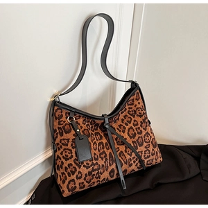 Détail du tissu à imprimé léopard et de la bandoulière en cuir noir du sac hobo