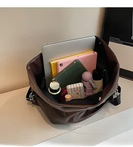 Internal view of dark brown tote bag showing its large capacity for laptops and daily items