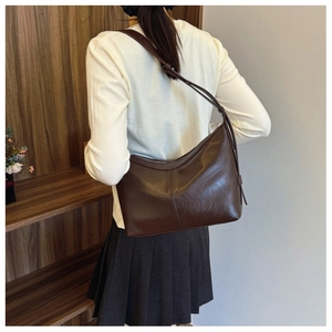 Detail of deep brown PU leather underarm bag featuring smooth texture and adjustable strap