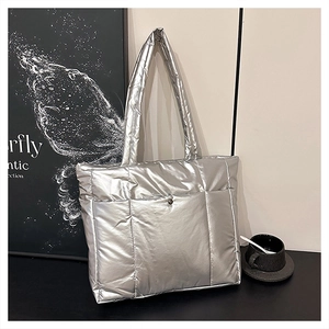 Détail rapproché du sac cabas matelassé argenté avec fermoir magnétique métallique