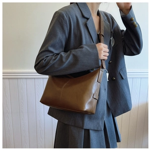 Close-up of vintage brown leather crescent bag with detailed stitching and shoulder strap