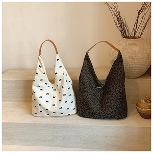 Minimalist canvas tote bags with bow and leopard prints featuring brown leather handles