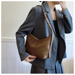 Brown leather hobo bag with contrast stitching styled on model with grey office blazer