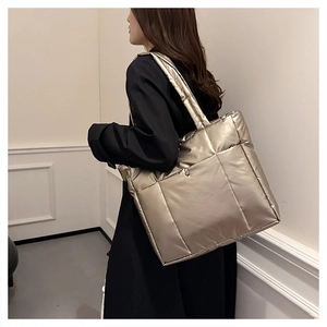 Détail du sac cabas matelassé doré champagne en nylon imperméable porté par un mannequin