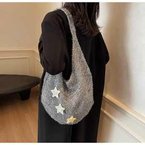 Detailansicht der grauen Stricktasche mit bunten Stern-Patches und Fransenkanten