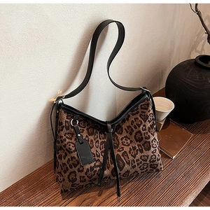 Vue détaillée du sac cabas à imprimé léopard avec lanières en cuir noir et bordures