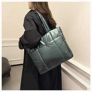 Sac fourre-tout matelassé en nylon vert métallisé porté à l'épaule sur un mannequin