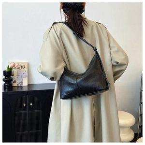 Detailed back view of a chic black textured leather underarm bag with adjustable strap