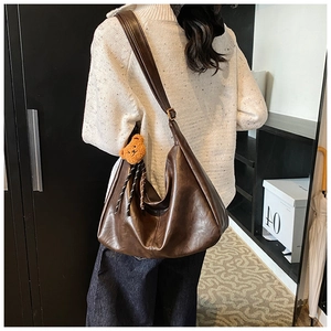 Retro dark brown matte leather hobo bag with a plush bear charm on adjustable strap