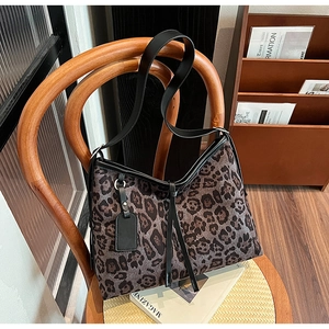 Vue détaillée du grand sac cabas imprimé léopard avec des anses en cuir noir sur chaise