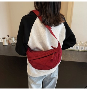 Quilted burgundy hobo bag with adjustable strap shown for size on model's shoulder
